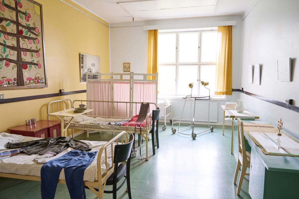 Sairaala-museon huoneessa sänkyjä ja laitteita. 